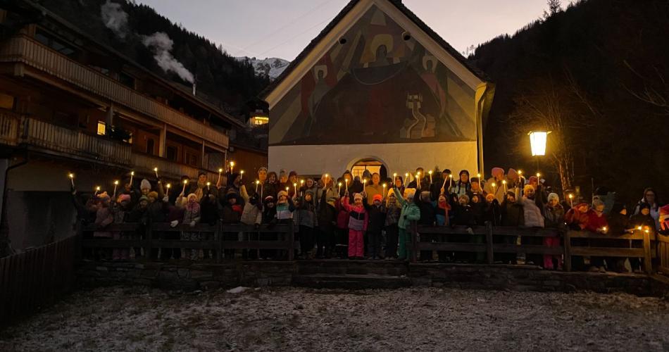 Kinder spazieren zur Bachkapelle mit Kerzen