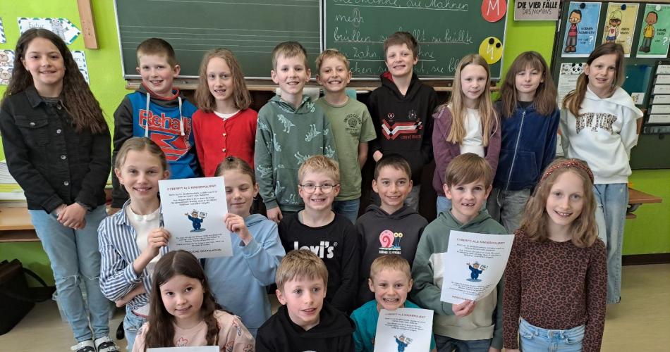 Die Kinder werden von einem Polizist über die Gefahren im Internet aufgeklärt.
