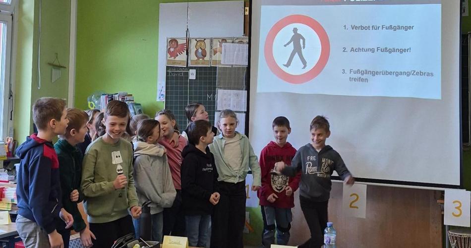 Kinder lernen etwas über Verkehrssicherheit mit einem Polizisten.