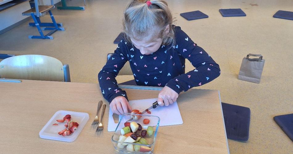 ein Kind schneidet Obst auf
