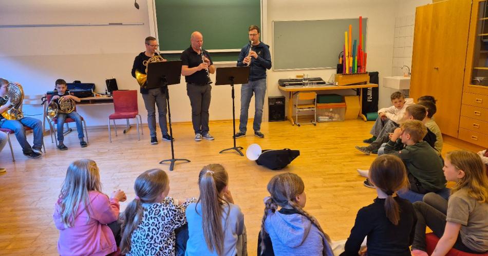 Drei Lehrer spielen auf ihren Instrumenten.