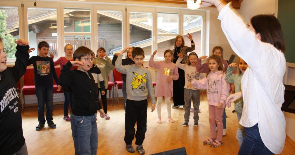 Die Kinder machen Aufwärmübungen fürs Singen.