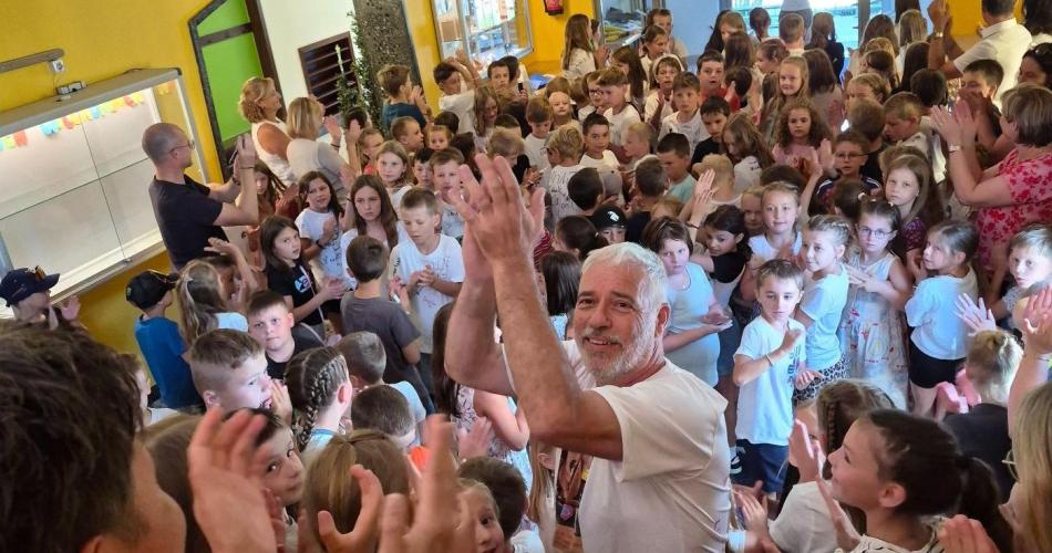 Schulwart Tom wird durch ein Spalier der Schulkinder durch das Schulhaus verabschiedet.