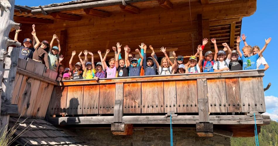 Die Kinder winken vom Balkon der Hütte.