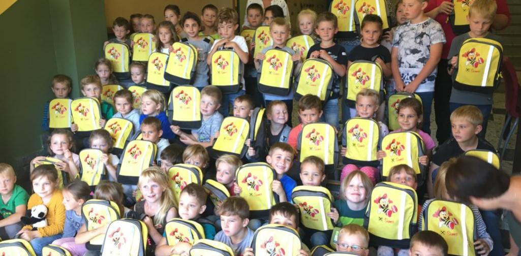 Kinder halten Sumsi Rücksäcke in ihrer Hand