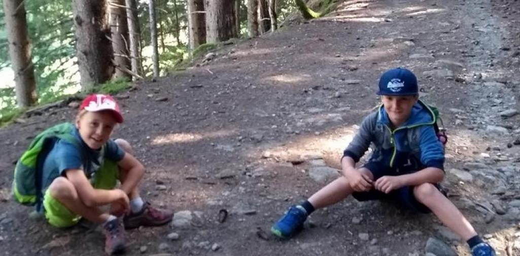 Kinder sitzen auf dem Weg